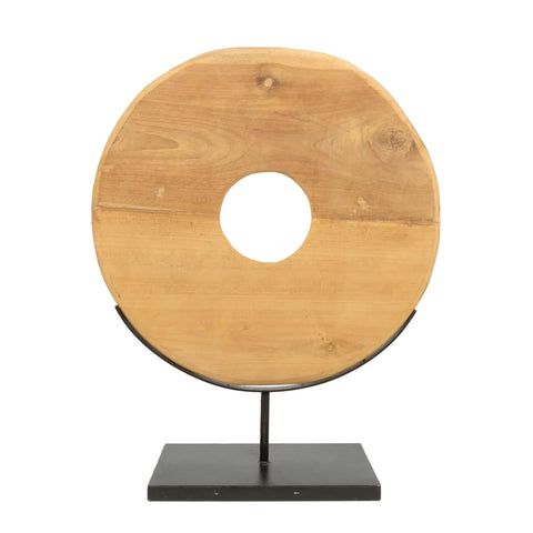 This teakwood display is a striking decorative item for your home interior, featuring a large circular disc with a central hole, all mounted on a sleek black metal stand. The natural wood grain adds texture and warmth to this elegant piece.