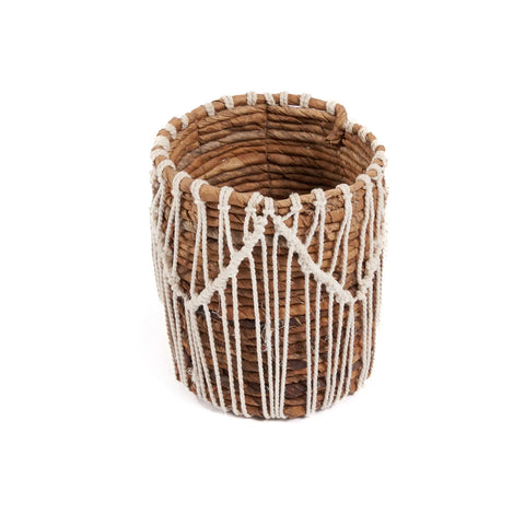 Introducing the Macra-Mazing Basket: a cylindrical woven piece infused with natural elegance. Crafted from brown natural fibers and adorned with a white rope in a macramé zigzag pattern, this basket boasts an open top and a textured surface for added charm.