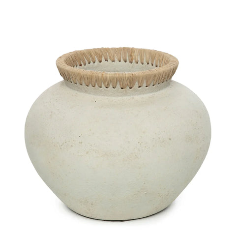 A round, light-colored ceramic vase with a wide opening features raffia detail on the rim, adding texture and contrast. This terracotta vase exudes rustic, handcrafted charm, perfect for infusing coastal vibes into any space.