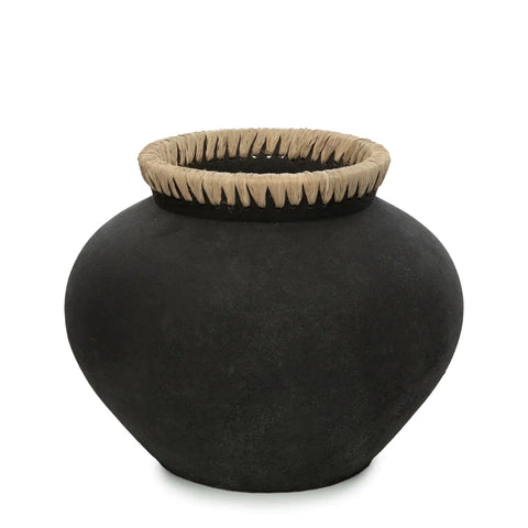 A large black clay pot with a wide, rounded body and a narrow opening. The rim is adorned with a braided design in raffia detail, adding a contrasting decorative touch. Perfect for arranging dried flowers, the surface appears smooth and matte.