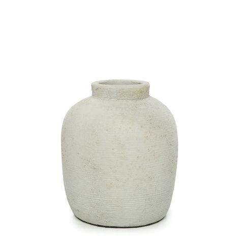 A rustic, round, light-gray clay vase with a narrow opening and a ribbed texture graces the plain white background. Reminiscent of terracotta vases, its subtle horizontal ridges add an air of elegance, perfect for showcasing dried flowers.