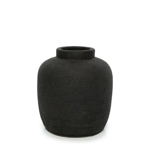 A textured, round black ceramic vase with a ribbed texture and narrow opening, set against a plain white background.