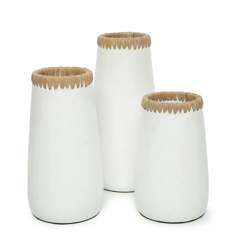 Three white ceramic vases of varying heights, featuring textured rims and subtle raffia details, are displayed against a plain background. The largest vase is positioned on the left, the medium one to the right, and the smallest in front.