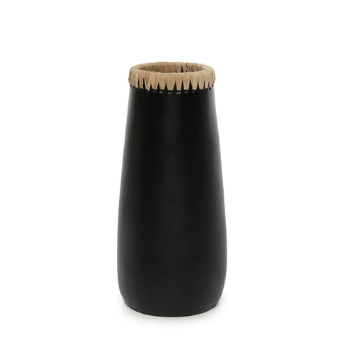 A tall, black ceramic vase with a narrow opening, adorned with a decorative beige woven band and subtle raffia detail around the top. It has a smooth, slightly tapered shape and minimalist design, ideal for showcasing dried flowers against a plain white background.