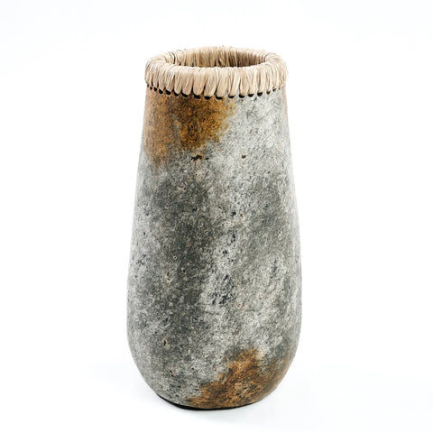 A tall, textured terracotta vase with a mottled gray and brown exterior. The top rim is wrapped in a woven material, adding a decorative touch perfect for showcasing dry flowers. The vase stands sleekly against a plain white background.