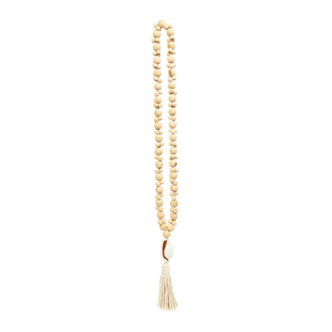 A long strand of beige wooden beads creates a necklace with a decorative white tassel at the bottom, offering a natural look that effortlessly complements any style.