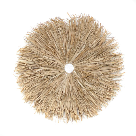 A round, woven straw wall decoration with radiating layers of natural fibers, resembling a sunburst or flower, centered on a white background—perfect for adding a touch of bohemian decor to your home interior.