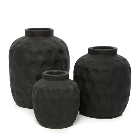 Three black ceramic vases of varying heights feature a ribbed texture with dotted patterns. Arranged together against a white background, they create a minimalist and stylish display, perfect for showcasing dried flowers.