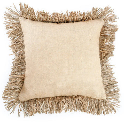 A square beige cushion with textured fabric features raffia fringes on the edges, adding a stylish touch to this piece of soft furnishings, laid flat against a white background.