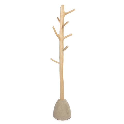 A tall, minimalist teak wood coat hanger resembling a wooden tree with several hook branches from a central trunk. It stands on a smooth, rounded concrete base, contrasting the natural wood finish, showcasing handmade wood art.