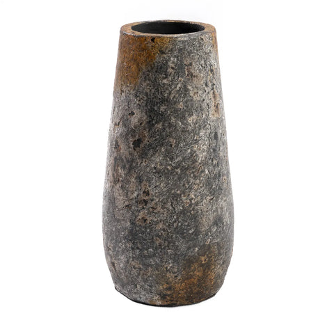 A tall, cylindrical stone vase with a rough, textured surface. This antique grey piece boasts earthy patches of brown. Its wide opening is perfect for displaying dried flowers, while the sturdy base adds to its charm.