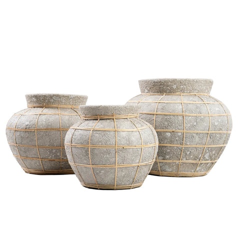 Three round, textured stone pots of varying sizes feature a grid pattern created by thin bamboo or reed strips, with subtle rattan details. They are arranged in a line against a plain white background, inviting the addition of dry flowers for a perfect touch.