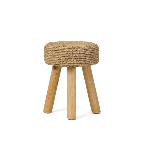 A small, handmade teak wood stool with a woven, round seat and three wooden legs arranged in a triangular pattern. The materials give it a rustic and natural appearance.