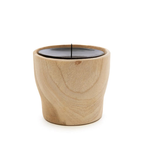 A black candle rests in a hand-carved teak wood holder. The unlit candle contrasts elegantly with the light wood grain, beautifully accentuated against a plain white background.