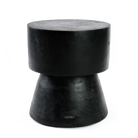 The Warmi stool features a sturdy, black cement construction with a cylindrical top and wider conical base. Its minimalist design blends modern and industrial aesthetics with a touch of futuristic design, adding sophistication to any space.