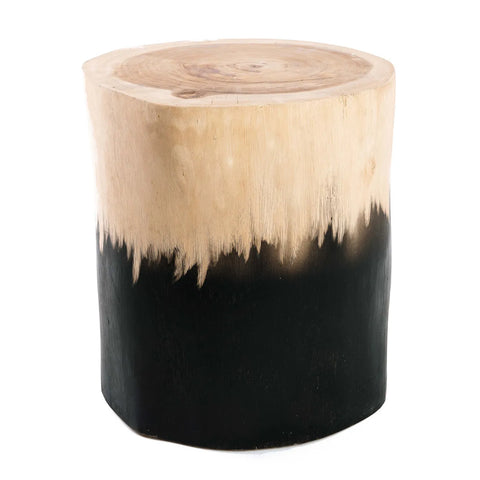 A dip-dyed wooden stool with a natural smooth top highlights suar wood's beauty. It showcases a two-tone design, with a lighter shade on the upper section and a dark, almost black finish below. The circular surface resembles a tree trunk slice, embodying the charm of chunky furniture.