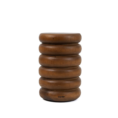 A small, round stool made from suar wood features a unique design with stacked, rounded layers, giving it an accordion-like appearance. The wood boasts a rich, dark brown finish, making this piece also suitable as a charming side table.