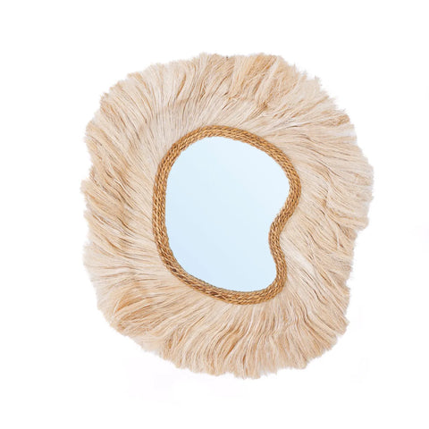 A decorative mirror with an irregular shape, surrounded by a frame of textured, light brown fibers resembling dried grass. The La Principessa mirror adds a coastal touch, giving the piece a rustic, natural appearance infused with refined luxury.