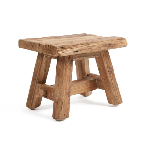 This rustic Shoji stool, crafted from reclaimed teak wood, features a rough-hewn, natural finish. Its flat rectangular seat and four sturdy legs beautifully showcase the wood's texture and imperfections, embodying a vintage and handmade appearance.