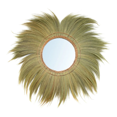 The Mufasa wall mirror features a round design framed by a woven rattan border and surrounded by radiating, feathery green palm leaves. This boho-inspired piece resembles a sunburst with natural, earthy tones.