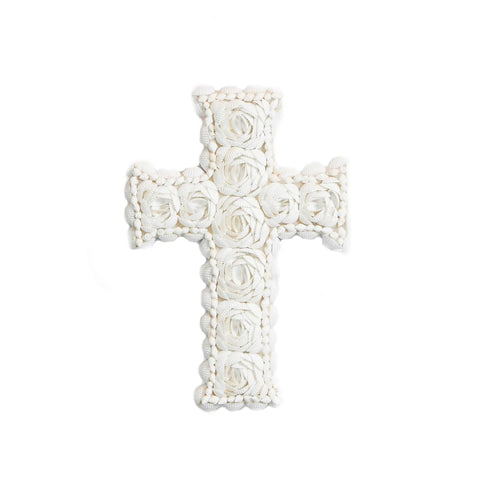 A decorative coastal cross intricately adorned with a pattern of white roses and small white shells gives a textured and delicate appearance on a plain white background.