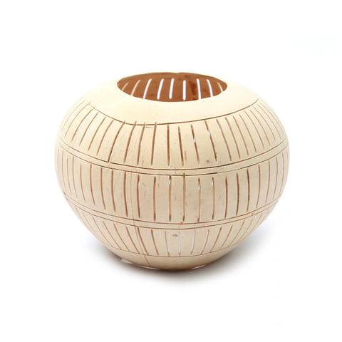 A round, beige bamboo basket with vertical slits crafted by Bali artisans, featuring a wide opening at the top, set against a plain white background.