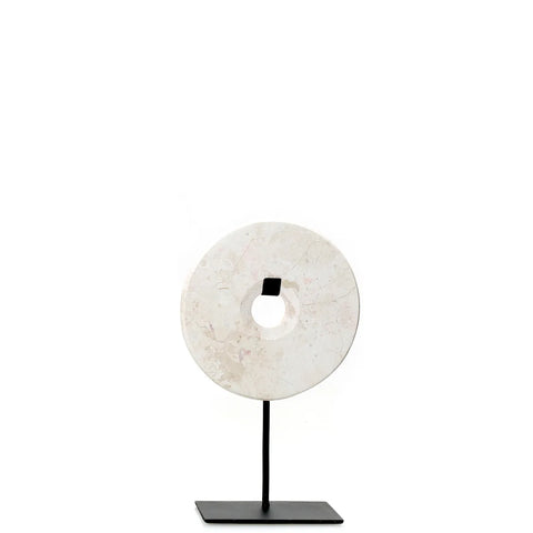 A circular stone sculpture with a central hole, this Marble Disc is elegantly mounted on a slender black metal stand. Its pale, marbled texture adds sophistication to any home interior or decorative display, perfectly centered against a plain white background.