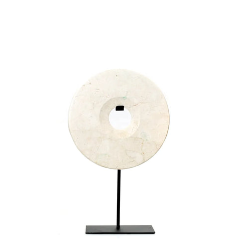 A white circular marble disc with a hole in the center is mounted on a thin black metal stand, creating a striking decorative display against a plain white background. Perfect for enhancing your home interior with an elegant touch.