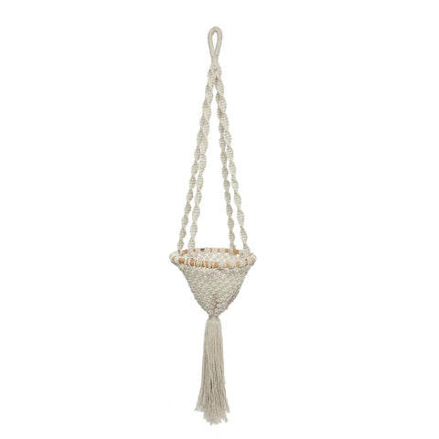 A beige macramé plant hanger with braided cords and a long tassel at the bottom elegantly cradles indoor plants, suspended against a plain white background.