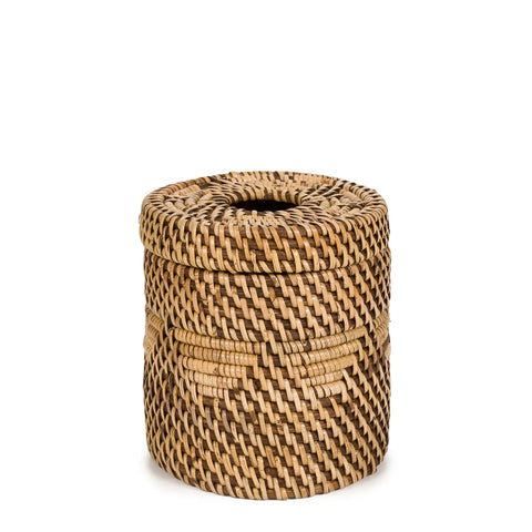 A small, round wicker basket with a tight weave pattern and a lid on top. Handwoven from natural fibers, it showcases a mix of light and dark brown colors. This charming basket sits against a plain white background.