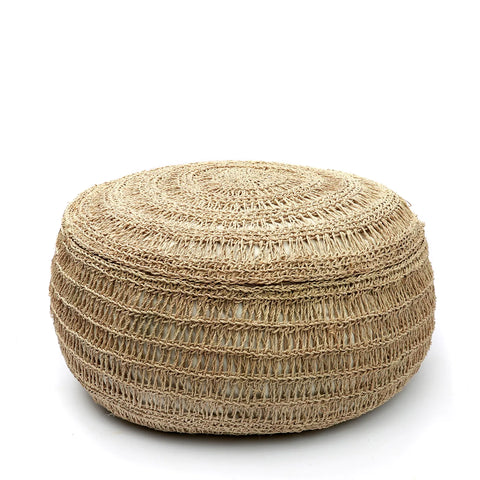 A handwoven round pouf made of natural fibers on a white background. The texture features intricate circular patterns, giving it a rustic and earthy appearance with a subtle boho touch.