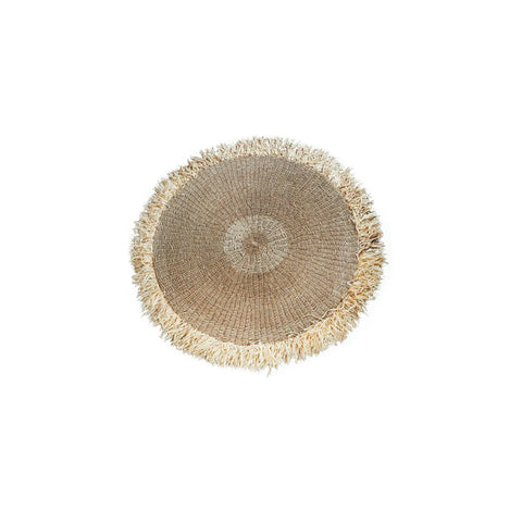 A round, hardwearing woven straw placemat with natural fringed edges on a plain white background.