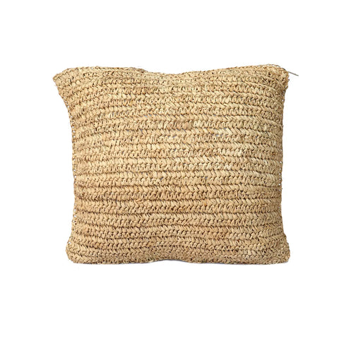 A square, beige woven pillow made of natural fibers exudes a boho style with its textured, straw-like appearance, reminiscent of Raffia cushions, against a plain white background.