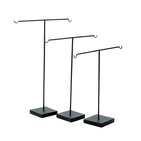 Three black metal T-bar jewelry stands, ideal as keychain holders, feature varying heights with square bases and horizontal bars with hooks on both ends. Perfect for adding a touch of style to your home interior, they're arranged in a row against a white background.