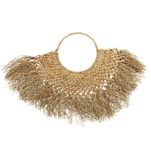 A woven straw handbag with a circular handle and fringed edges, featuring an intricate knotted pattern and coastal texture for an earthy boho vibe.