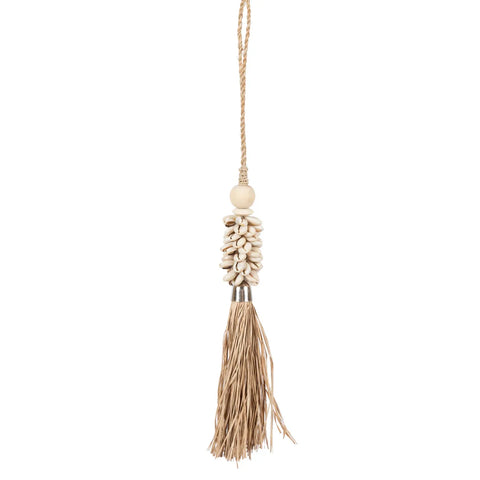 A decorative tassel showcases a bohemian atmosphere with a cluster of small white cowrie shells and a single wooden bead at the top. Made of long, beige natural fibers, it elegantly hangs from a thin rope.