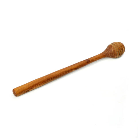 The Teak Root Honey Roller is a luxury honey dipper with a long handle and a grooved, rounded end. Crafted from wood with a smooth finish and natural brown color, it's the perfect table accessory. The grooves efficiently hold honey for easy drizzling against a crisp white background.