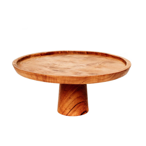 A round teak wood cake stand with a smooth finish and natural grain patterns, perfect for displaying sweets on a decorated table. It features a wide, flat surface on top and a sturdy, cylindrical base.