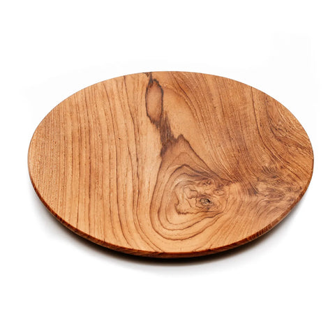 A round wooden serving board, crafted from teak wood, showcases a smooth surface and natural grain patterns, perfect as a table decoration. Set against a plain white background, its elegance stands out.