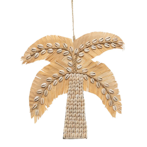 A tropical hanging decoration, this palm tree decor is handmade in Bali from beige straw and adorned with rows of cowrie shells that form the trunk and leaves. Suspended by a thin cord, it brings an authentic island vibe to any space.