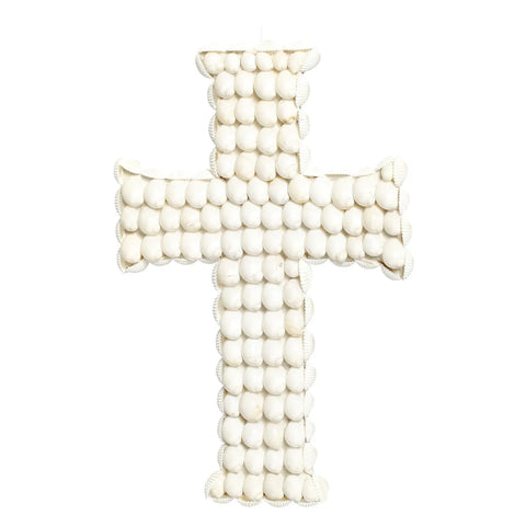 A cross made of white shells arranged in a grid pattern against a plain white background, embodying the essence of coastal decoration.