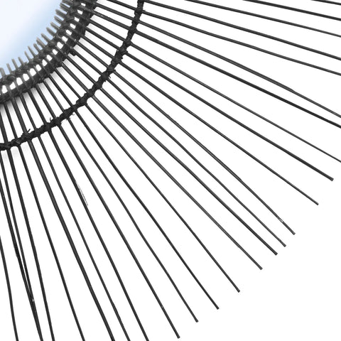 A close-up view of a modern black wire lampshade in a radial pattern, set against a white background. The design evokes a 70s inspired mirror aesthetic, with its wires fanning out symmetrically to create a visually striking geometric effect.