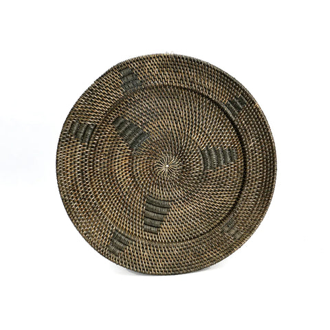 A handwoven plate exuding a natural vibe features a detailed, textured pattern in rich brown shades. Its design showcases alternating dark and light sections, crafting a geometric effect. This flat basket is displayed against a white background, perfect as an ethnic wall display.