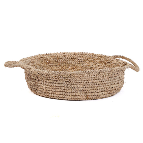 A round raffia basket tray with two handles made from natural fiber, displayed on a white background. Perfect for home interior styling, the basket offers a textured, rustic appeal ideal for storage and organization.